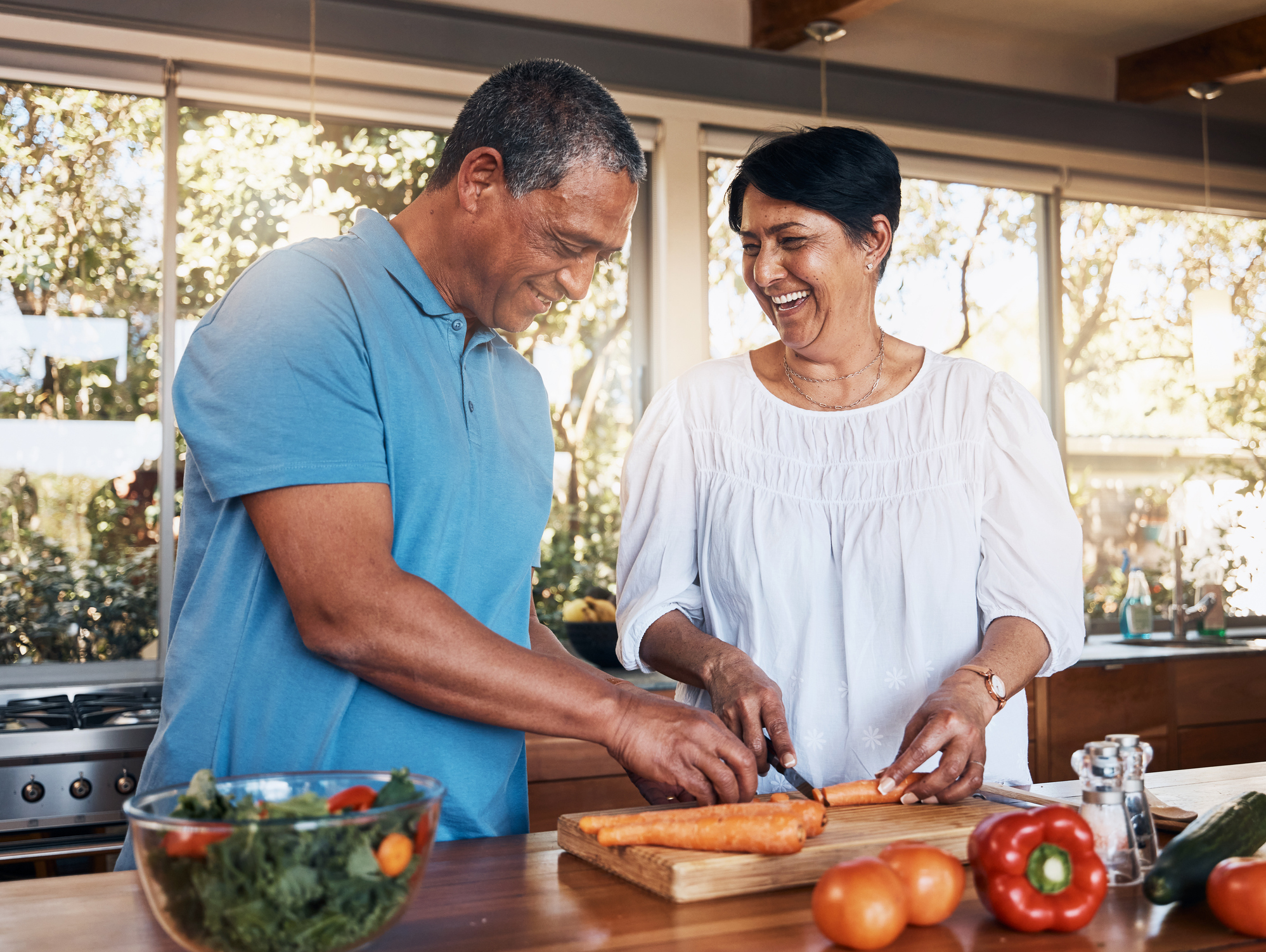 Mature couple and healthy cooking in kitchen to chop vegetables for salad diet nutrition and lunch meal at home Happy man woman and help cut carrot ingredients for love care and support together - Maryland Weight Care how to keep yourself motivated to lose weight