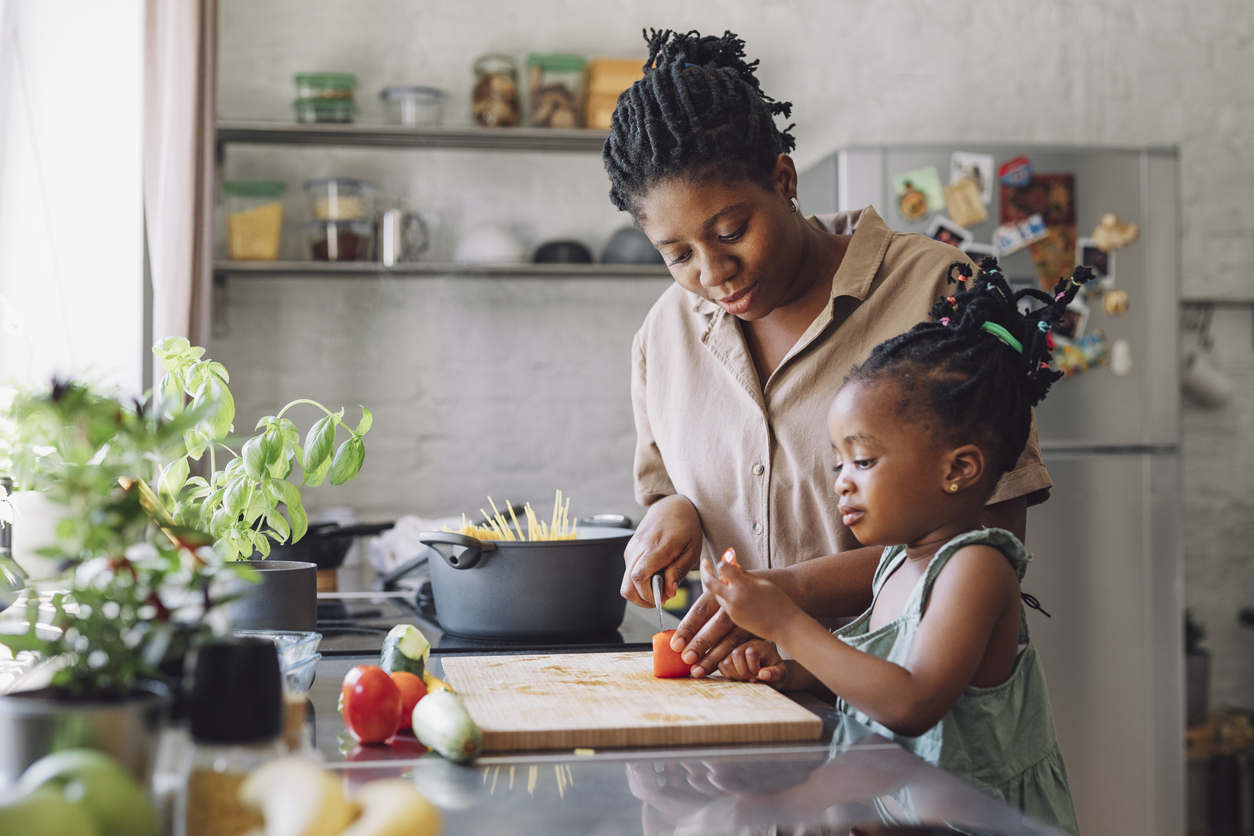Mother and Daughter Cutting a Tomato for Lunch in a Kitchen - Maryland Weight Care